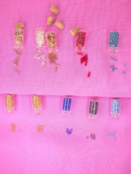 Set of 10 glass bottles of seed beads and 10 needles